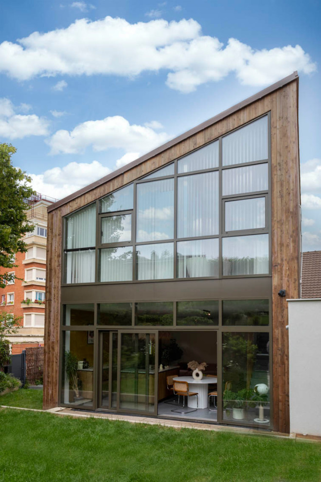 Cette photo montre une grande façade de maison marron en bois à un étage avec un toit en appentis, un toit en métal et un toit marron.