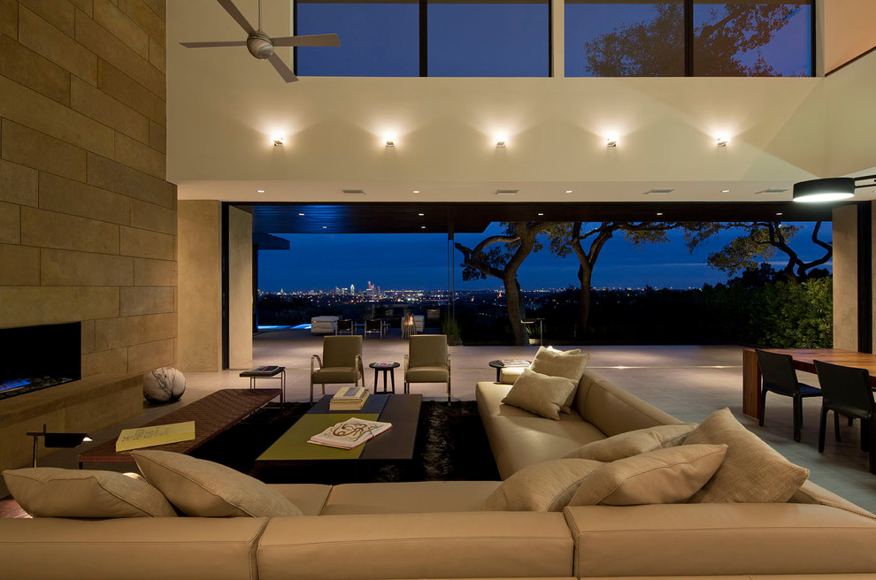 This is an example of a contemporary open concept living room in Austin with a ribbon fireplace.