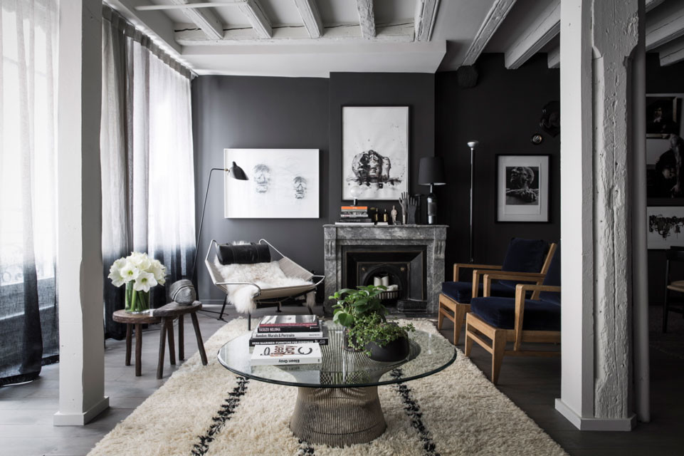 Inspiration for a large contemporary open concept family room in Los Angeles with black walls, dark hardwood floors, a standard fireplace, a stone fireplace surround, no tv and brown floor.