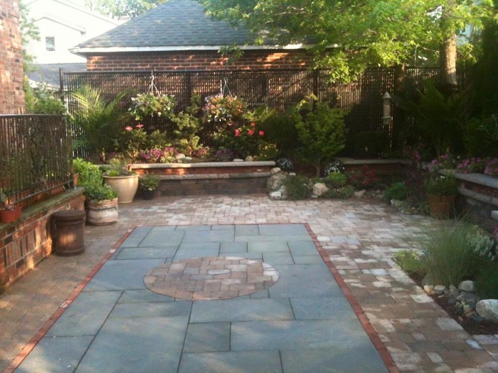 Mid-sized traditional backyard patio in Other with a container garden, brick pavers and no cover.