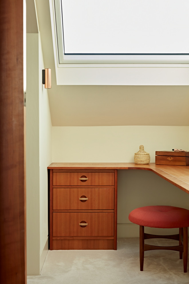 Foto di un piccolo spazio per vestirsi unisex minimalista con ante lisce, ante in legno scuro, moquette, pavimento beige e soffitto a volta