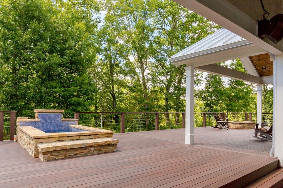 This is an example of an arts and crafts backyard deck in Atlanta with a water feature and a roof extension.