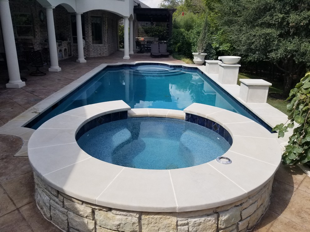 Photo of a large traditional backyard rectangular natural pool in Dallas with a water feature and tile.