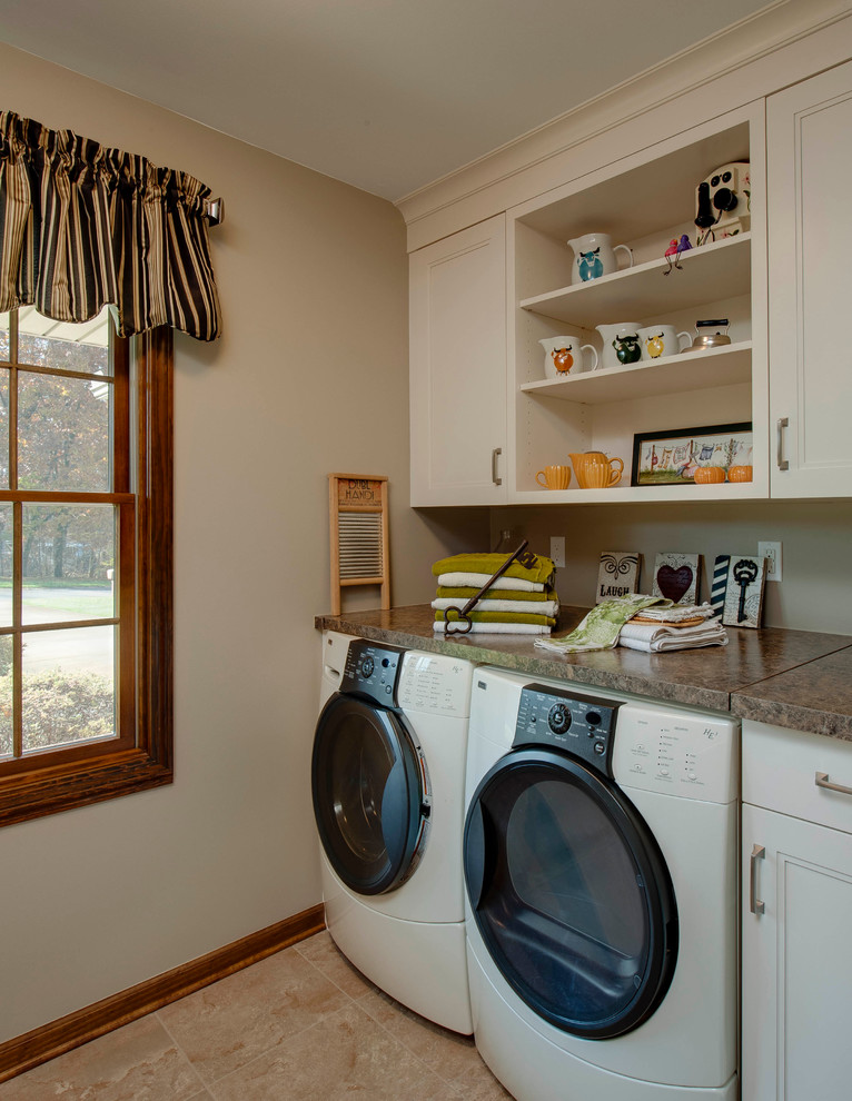 This is an example of a large transitional l-shaped laundry room in Detroit with an undermount sink, shaker cabinets, medium wood cabinets, quartz benchtops, white splashback, stone tile splashback and light hardwood floors.