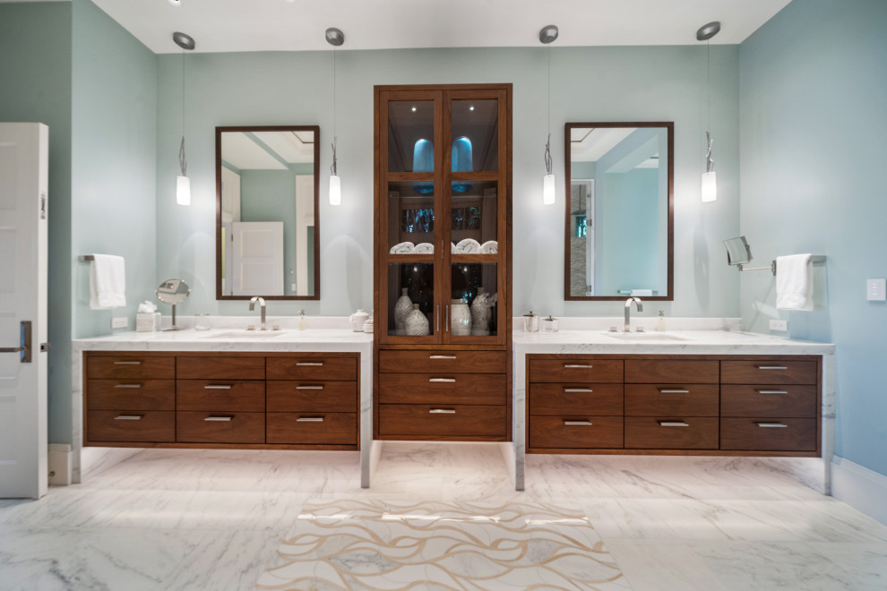 マイアミにあるコンテンポラリースタイルのおしゃれな浴室 (ガラス扉のキャビネット、置き型浴槽、白いタイル、マルチカラーの床、白い洗面カウンター、洗面台2つ、造り付け洗面台) の写真