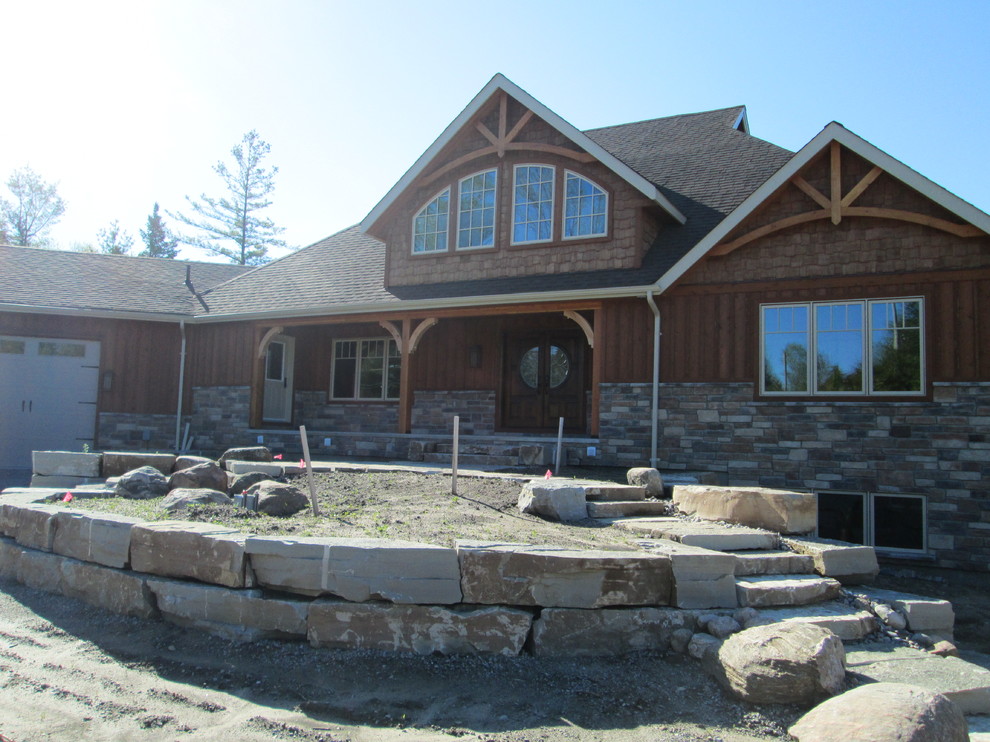 Inspiration for a large traditional two-storey brown exterior in Toronto with stone veneer and a gable roof.