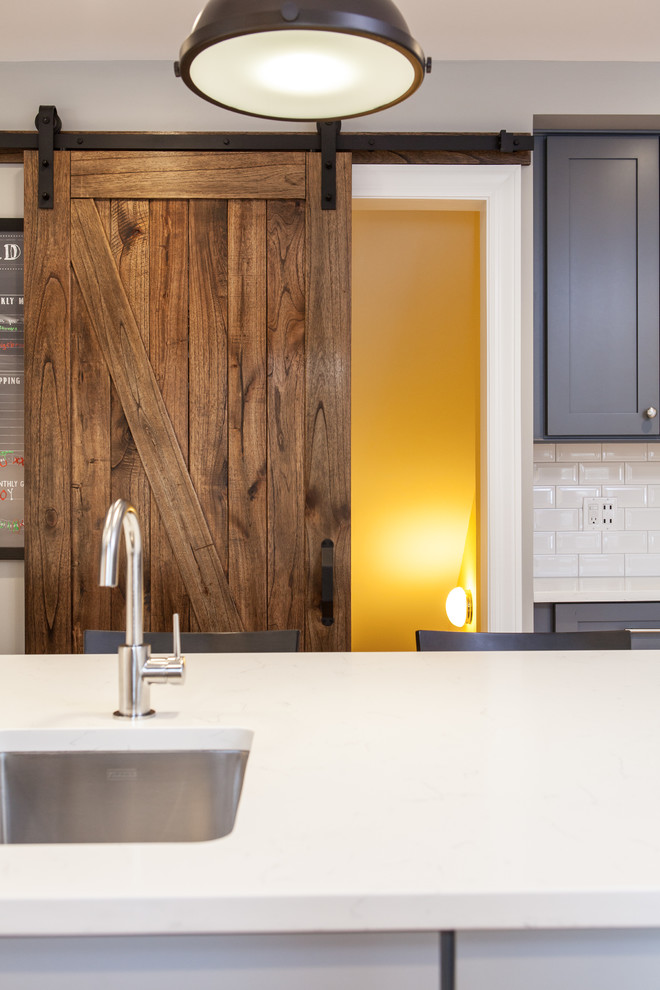 Large transitional galley light wood floor eat-in kitchen photo in Chicago with a drop-in sink, beaded inset cabinets, gray cabinets, quartz countertops, white backsplash, subway tile backsplash, stainless steel appliances and an island