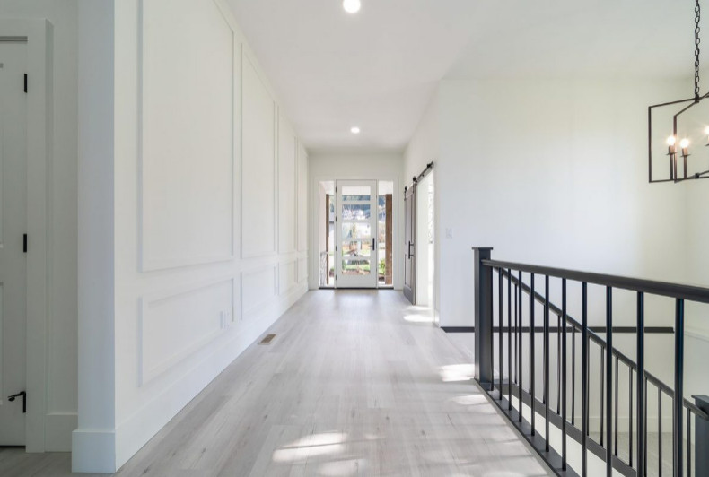 This is an example of a mid-sized arts and crafts foyer in Vancouver with white walls, laminate floors, a single front door, a white front door, beige floor and panelled walls.