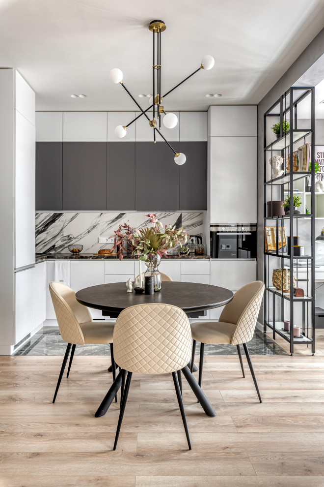 Стильный дизайн: прямая, глянцевая, серо-белая кухня-гостиная среднего размера в скандинавском стиле с плоскими фасадами, полом из керамогранита и черным полом - последний тренд