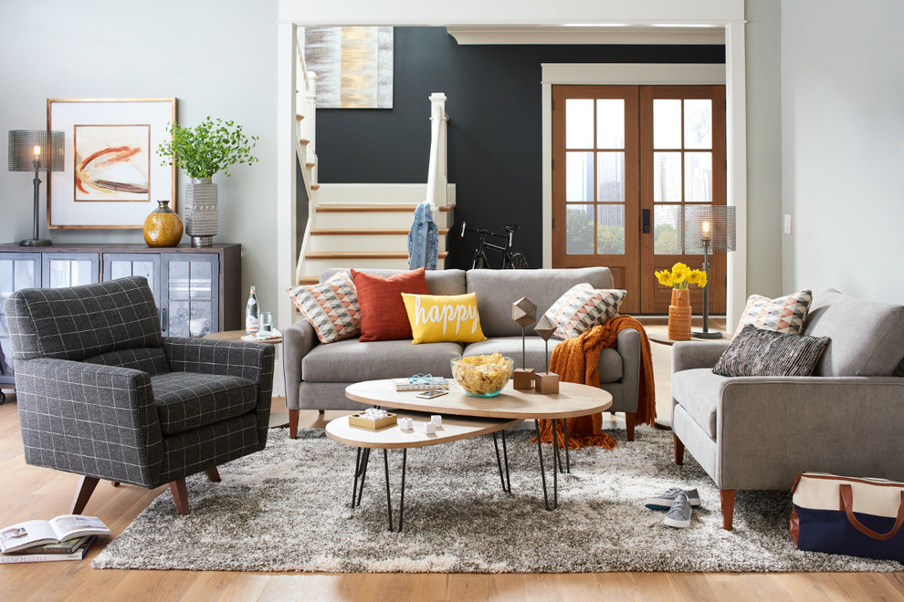 Inspiration for a mid-sized modern open concept light wood floor and brown floor living room remodel in Charlotte with gray walls, no fireplace and no tv