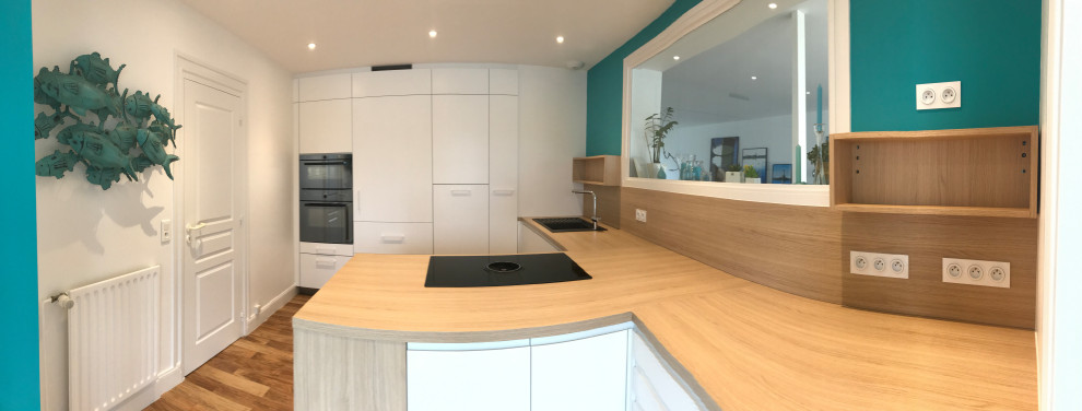 This is an example of a mid-sized beach style separate kitchen in Nantes with a single-bowl sink, flat-panel cabinets, white cabinets, laminate benchtops, panelled appliances, dark hardwood floors and a peninsula.