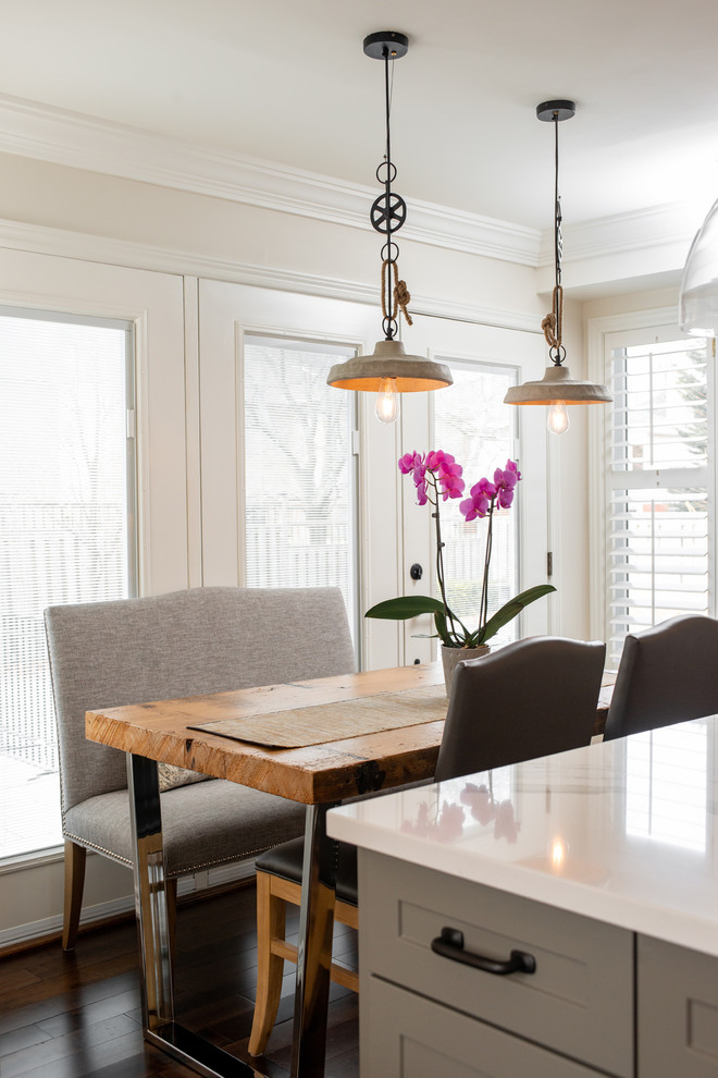 Example of a transitional dark wood floor and brown floor kitchen design with white cabinets, quartz countertops, paneled appliances, an island and white countertops