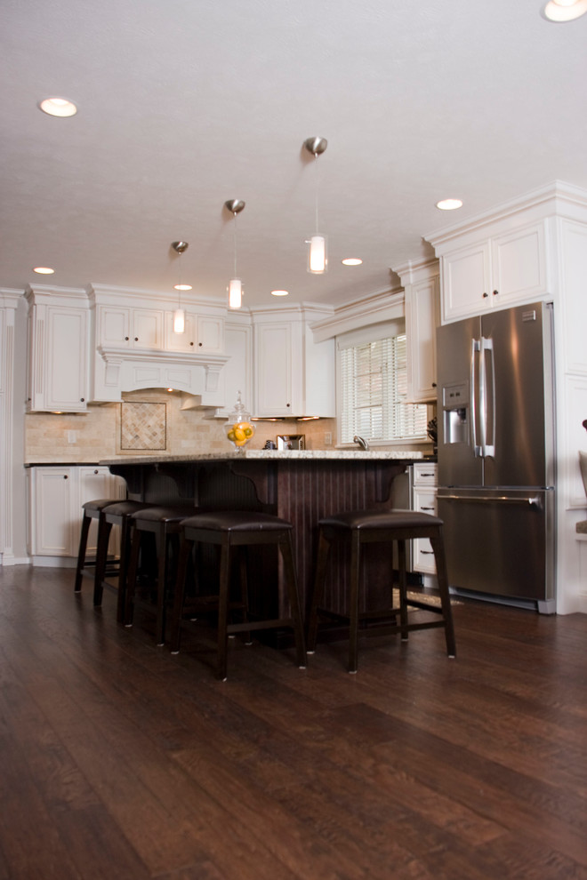 Large transitional u-shaped medium tone wood floor kitchen photo in Cincinnati with an undermount sink, recessed-panel cabinets, white cabinets, granite countertops, beige backsplash, stone tile backsplash, stainless steel appliances and an island
