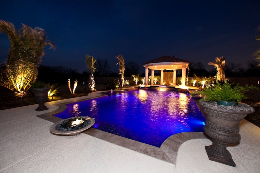 Inspiration for a mediterranean backyard custom-shaped pool in Houston with a pool house and concrete slab.