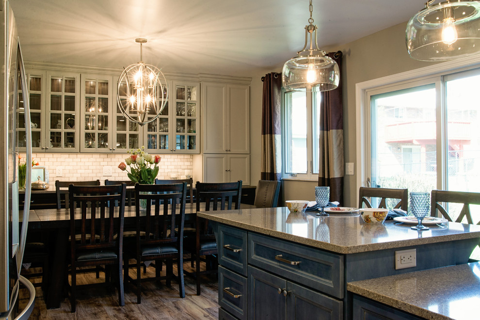 Inspiration for a mid-sized transitional l-shaped vinyl floor eat-in kitchen remodel with an undermount sink, recessed-panel cabinets, gray cabinets, quartz countertops, white backsplash, marble backsplash, stainless steel appliances and an island