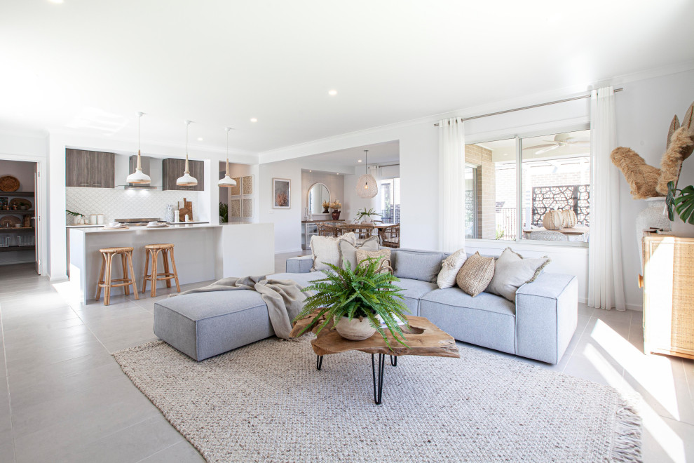Photo of a large tropical open concept family room in Melbourne with white walls, ceramic floors and grey floor.