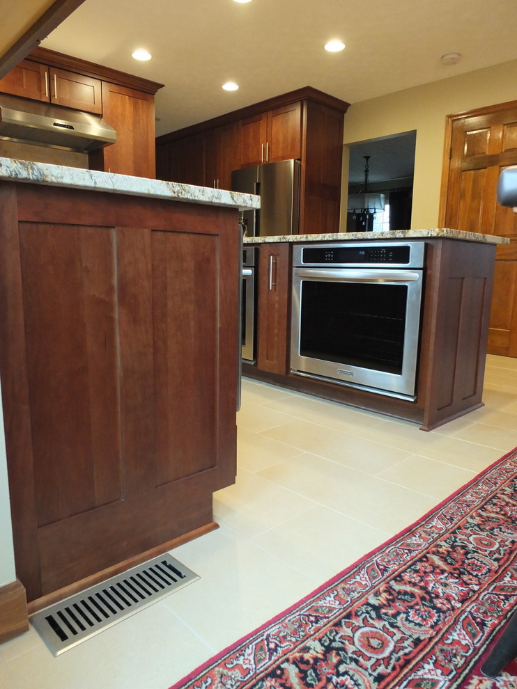 Eat-in kitchen - mid-sized transitional l-shaped ceramic tile eat-in kitchen idea in Columbus with an undermount sink, shaker cabinets, brown cabinets, granite countertops, beige backsplash, ceramic backsplash, stainless steel appliances and an island