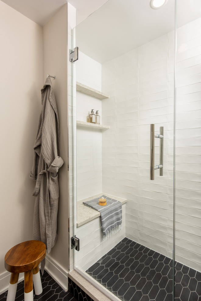 Cette photo montre une grande salle de bain tendance avec un mur beige, un sol noir, une cabine de douche à porte battante et un sol en calcaire.