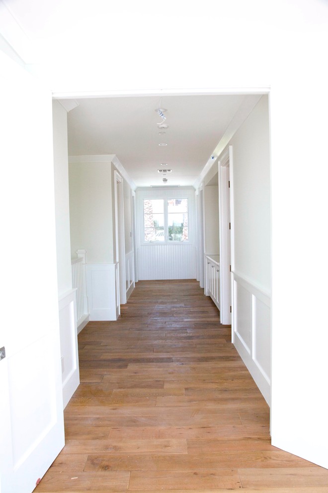 Inspiration for a large beach style hallway in Los Angeles with white walls and medium hardwood floors.
