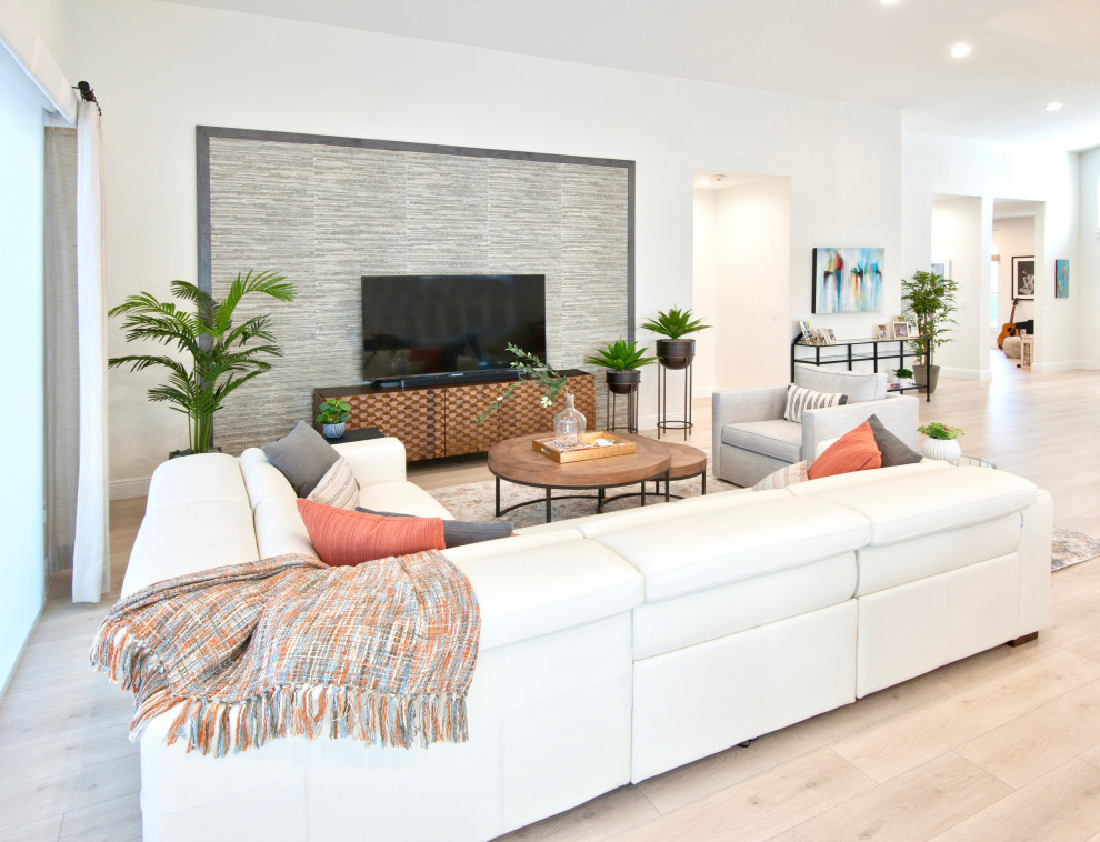 Großes, Offenes Maritimes Wohnzimmer mit weißer Wandfarbe, Laminat, freistehendem TV, beigem Boden und Steinwänden in Miami