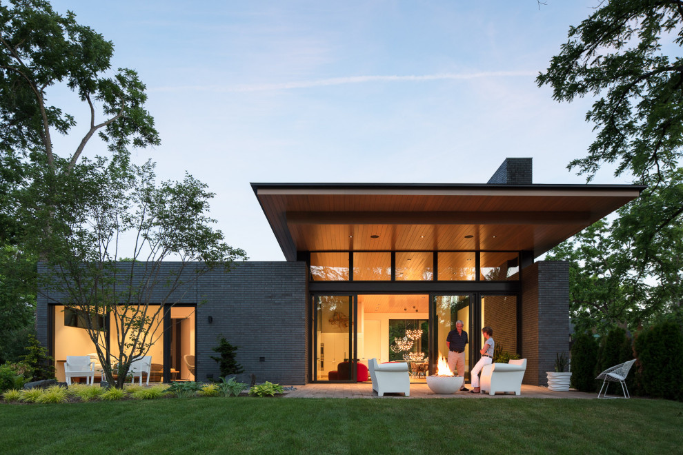 Cette photo montre une façade de maison moderne en brique de plain-pied avec un toit plat.