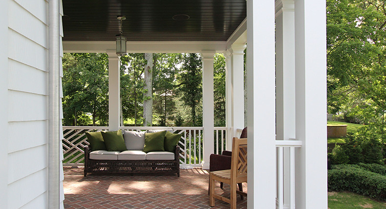 This is an example of a mid-sized transitional backyard verandah in New York with brick pavers and a roof extension.