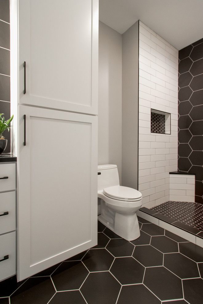 Example of a transitional porcelain tile and black floor doorless shower design with recessed-panel cabinets, white cabinets, a two-piece toilet, white walls, quartz countertops, black countertops and a built-in vanity