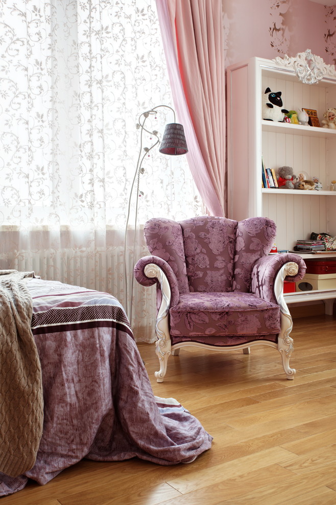 This is an example of a traditional kids' room for kids 4-10 years old and girls in Moscow with pink walls and medium hardwood floors.