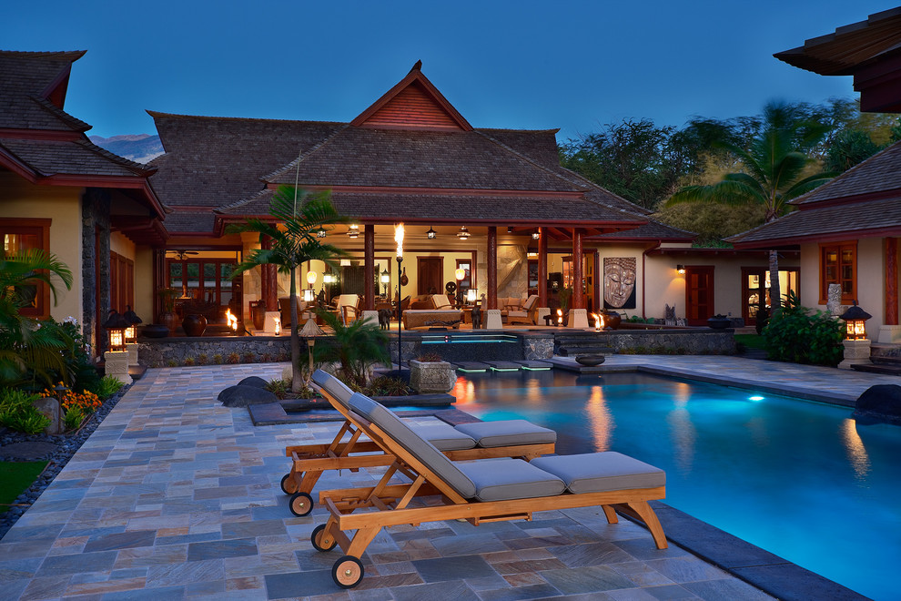 Photo of a mid-sized asian courtyard rectangular infinity pool in Hawaii with a hot tub and natural stone pavers.