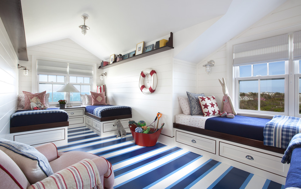 Photo of a large beach style gender-neutral kids' bedroom for kids 4-10 years old in Boston with white walls, painted wood floors and multi-coloured floor.