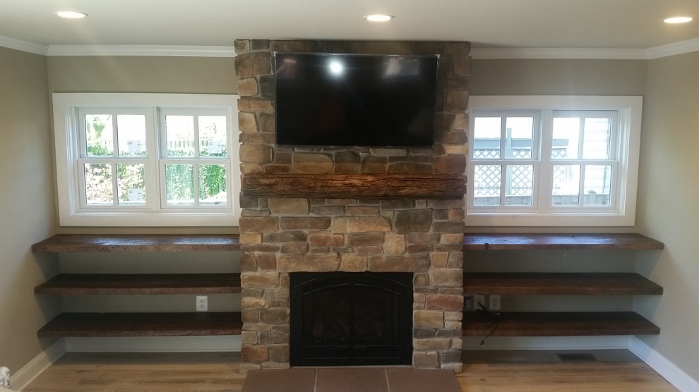 Inspiration for a country family room in DC Metro with beige walls, light hardwood floors, a standard fireplace, a stone fireplace surround and a wall-mounted tv.