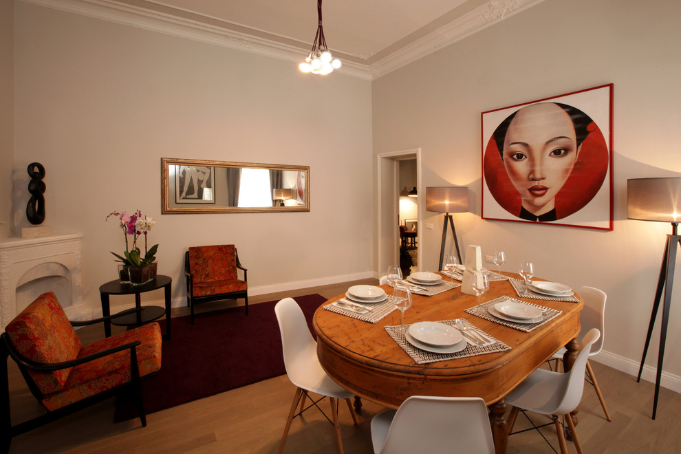Photo of a mid-sized eclectic separate dining room in Rome with beige walls, a corner fireplace, beige floor, light hardwood floors and a plaster fireplace surround.