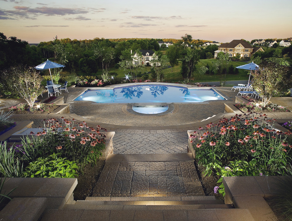 Mid-sized traditional custom-shaped natural pool in DC Metro with concrete pavers and a hot tub.