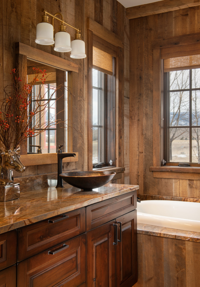 Inspiration for a mid-sized country 3/4 bathroom in Other with raised-panel cabinets, medium wood cabinets, a drop-in tub, blue walls, a vessel sink, brown benchtops, a built-in vanity and wood walls.