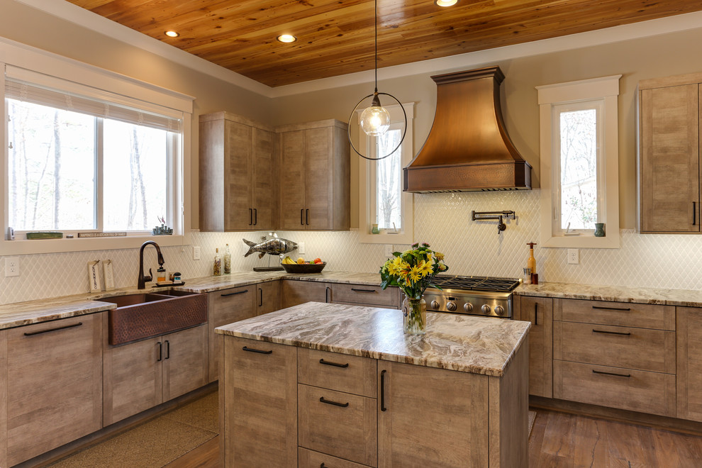 Large transitional u-shaped open plan kitchen in Raleigh with a farmhouse sink, flat-panel cabinets, marble benchtops, panelled appliances, medium hardwood floors, medium wood cabinets, white splashback, mosaic tile splashback, with island, brown floor and beige benchtop.