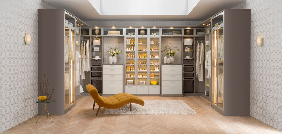 Design ideas for a large modern women's walk-in wardrobe in Nashville with light hardwood floors, flat-panel cabinets and beige cabinets.