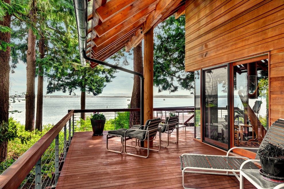 Deck - rustic hillside deck idea in Seattle with decking and a roof extension