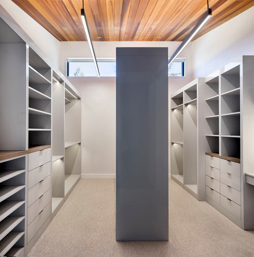 Design ideas for a medium sized contemporary wardrobe in Denver with medium hardwood flooring.