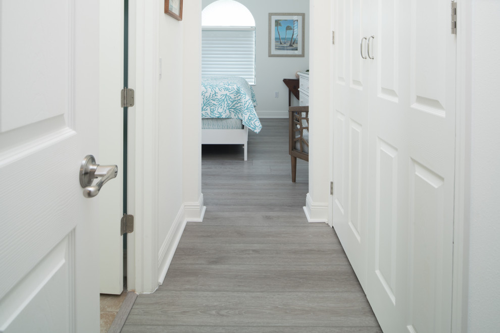 Inspiration for a mid-sized beach style hallway in Orlando with vinyl floors, grey floor and white walls.
