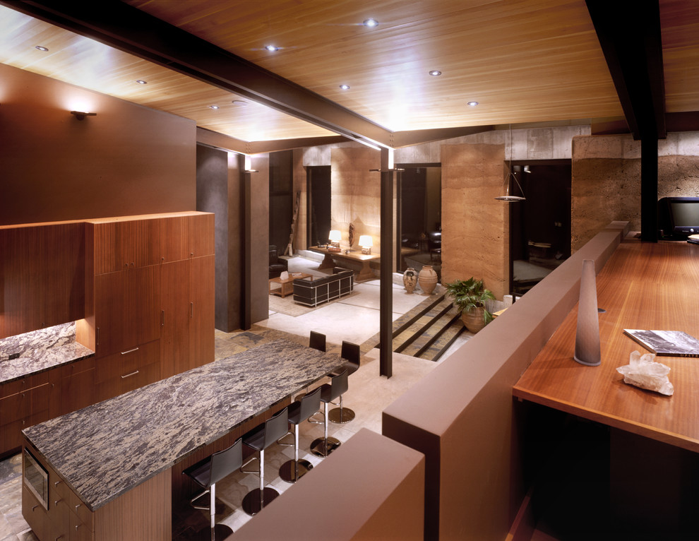 Mid-sized minimalist l-shaped eat-in kitchen photo with medium tone wood cabinets, an island, flat-panel cabinets, stone slab backsplash and stainless steel appliances