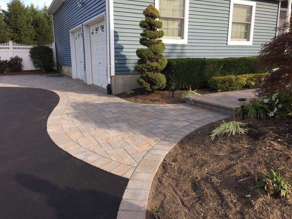 Design ideas for a contemporary front yard driveway in New York with concrete pavers.