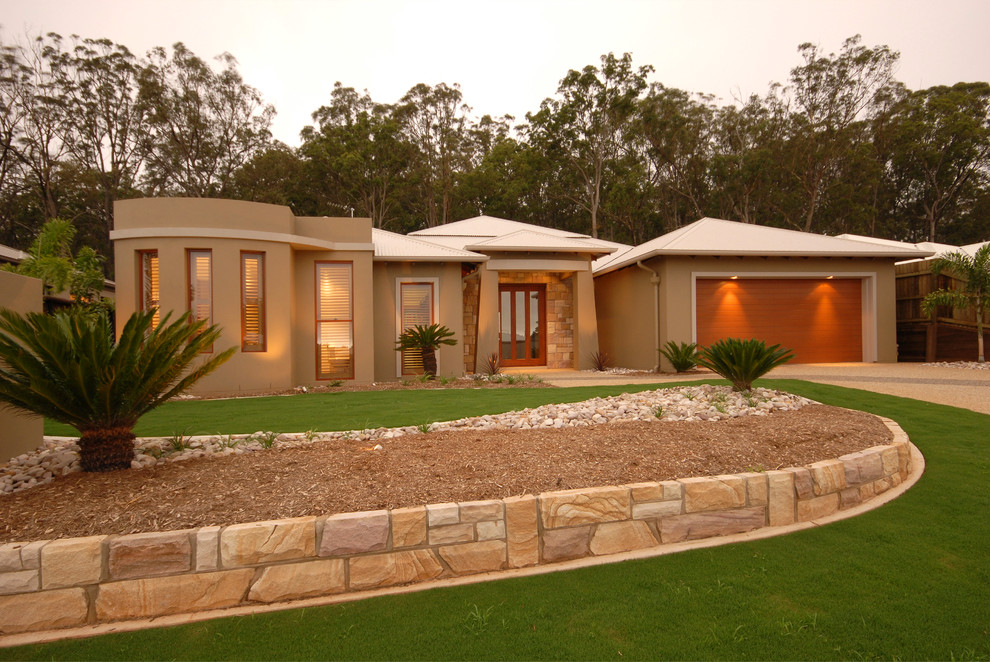 This is an example of a modern front yard full sun garden in Brisbane with a garden path.