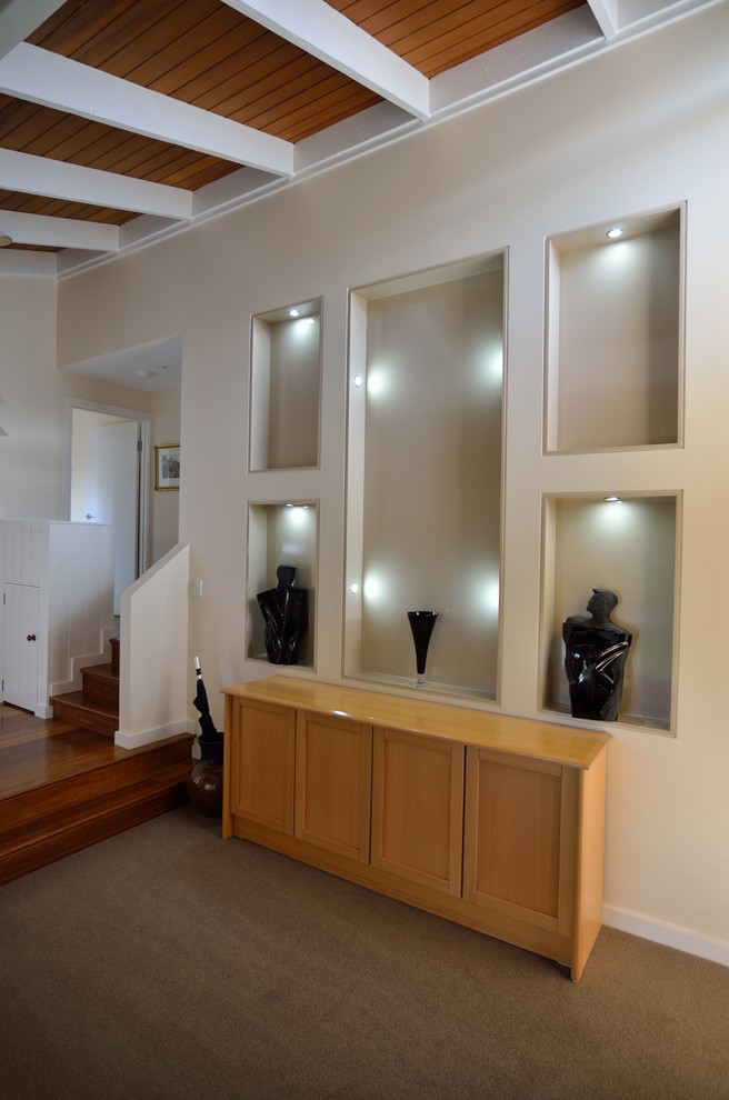 This is an example of a mid-sized modern foyer in Melbourne with beige walls, bamboo floors, a single front door and a red front door.