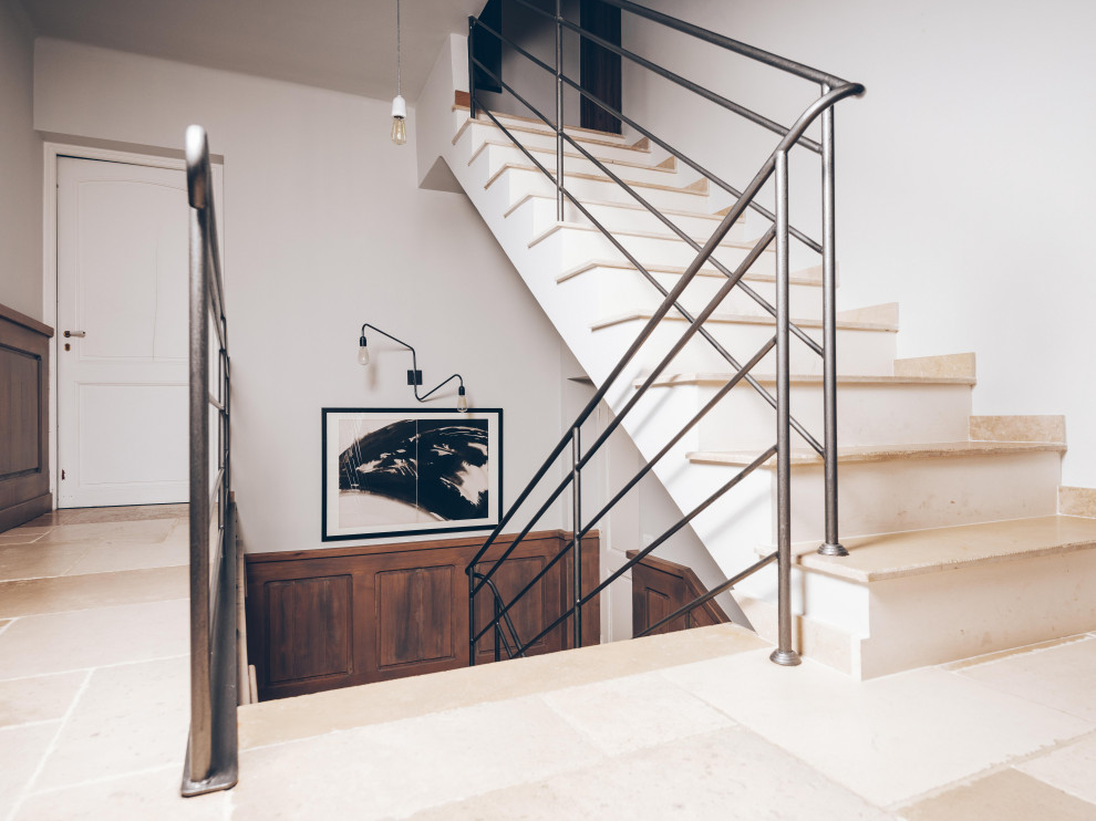 Small mediterranean limestone u-shaped staircase in Nice with concrete risers and metal railing.