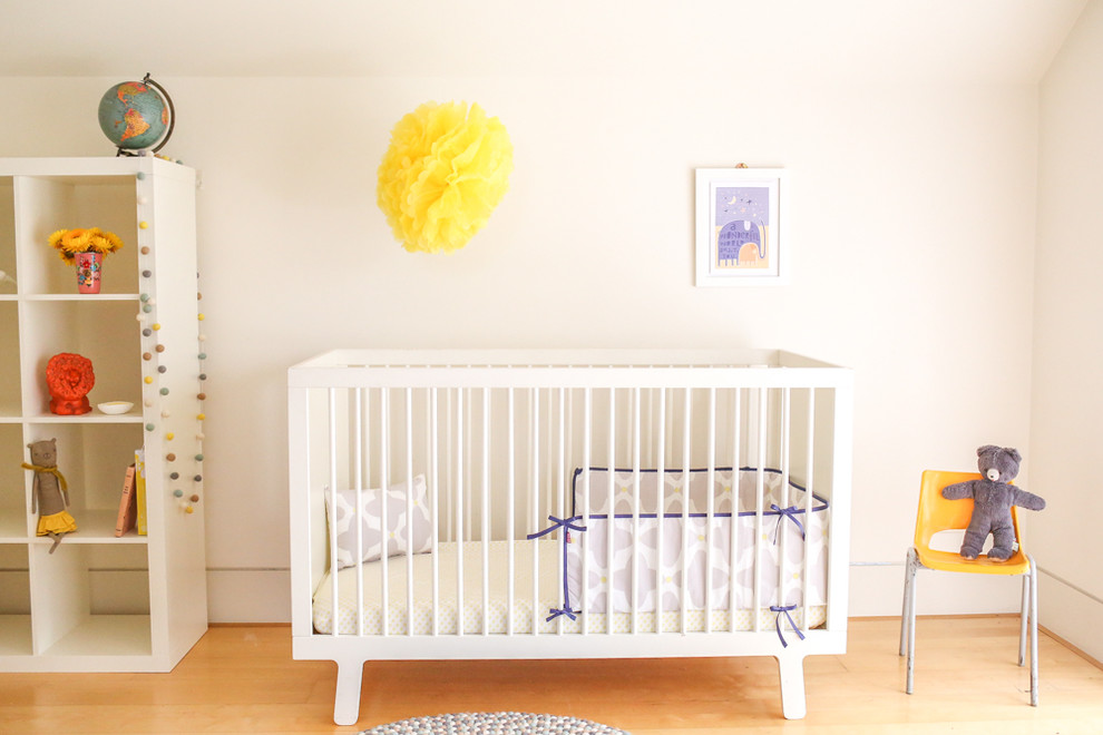 Photo of a mid-sized contemporary gender-neutral nursery in Sydney with white walls and light hardwood floors.