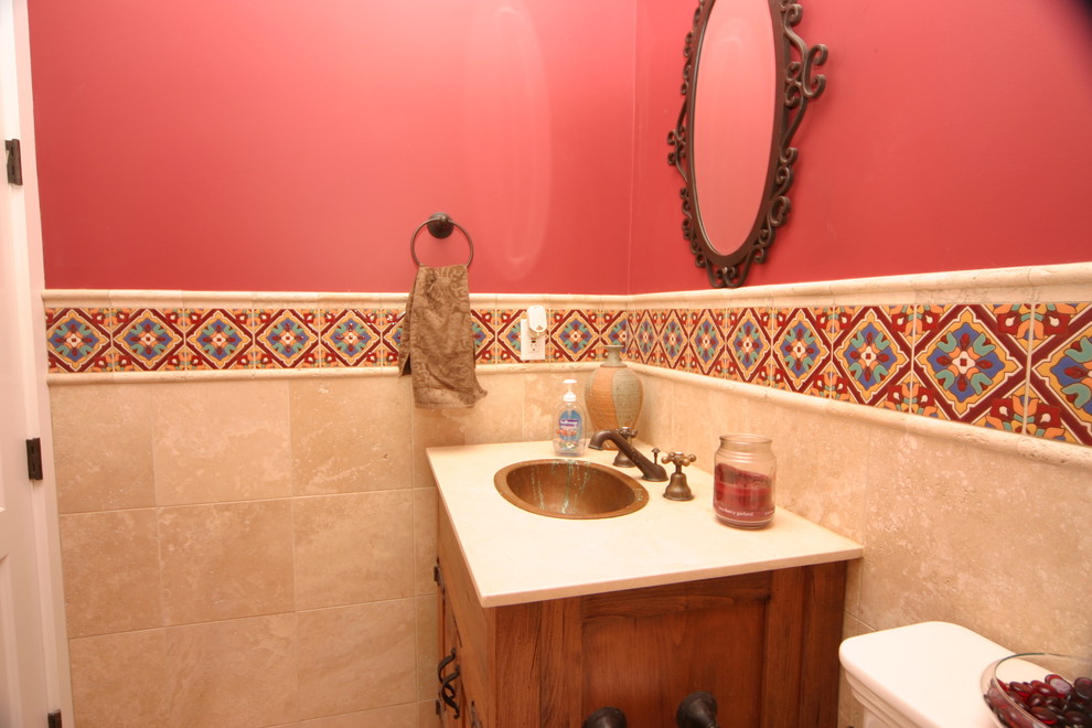 Design ideas for a mid-sized mediterranean 3/4 bathroom in Orange County with shaker cabinets, dark wood cabinets, a two-piece toilet, red walls, ceramic floors, a drop-in sink and marble benchtops.