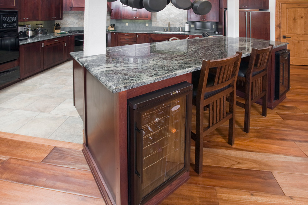 Open concept kitchen - large transitional l-shaped porcelain tile open concept kitchen idea in Denver with an undermount sink, shaker cabinets, red cabinets, granite countertops, gray backsplash, stone tile backsplash, black appliances and an island