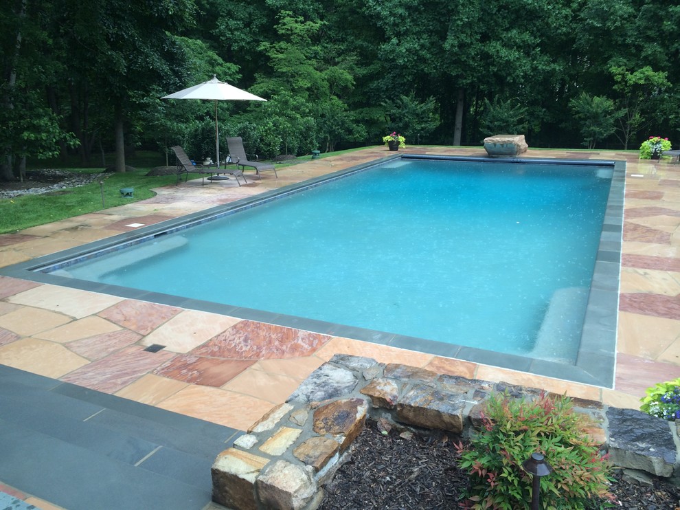 Large backyard stone and rectangular pool photo in Baltimore