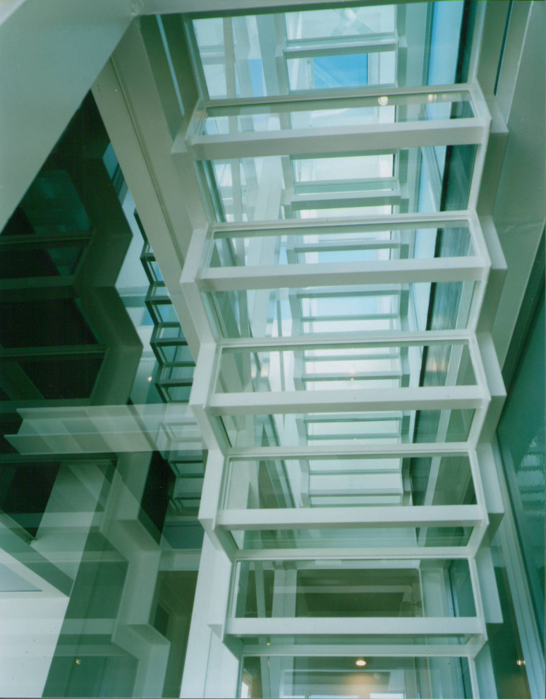 他の地域にある高級な小さなインダストリアルスタイルのおしゃれなスケルトン階段 (ガラスの蹴込み板、金属の手すり) の写真