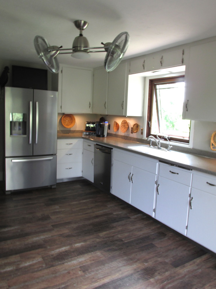 This is an example of a mid-sized country galley separate kitchen in Chicago with an integrated sink, white cabinets, stainless steel appliances and no island.